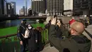 Jose Rochelle dan ibunya Theresa berfoto dekat Sungai Chicago yang berwarna hijau jelang Hari Santo Patrick di Chicago, Amerika Serikat, Sabtu (13/3/2021). Kegiatan mewarnai Sungai Chicago dalam memperingati Hari Santo Patrick sudah berlangsung selama 40 tahun. (Pat Nabong/Chicago Sun-Times via AP)