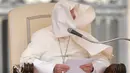 Wajah Paus Fransiskus tertutup jubahnya yang tetiup oleh angin ketika sedang memberikan ceramah pada acara audiensi umum di Lapangan Santo Petrus, Vatikan, Rabu (16/5). Terpaan angin tak menganggu Paus memberikan khotbah. (AFP PHOTO/Andreas SOLARO)