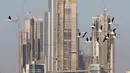 Burung flamingo terbang bermigrasi melewati gedung tertinggi di dunia, Burj Khalifa di Dubai, Uni Emirat Arab (28/1). Meski terdiri dari gedung-gedung mewah, pemerintah Dubai tetap menjaga habitat burung flamingo. (AP Photo / Kamran Jebreili)