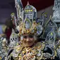 Senyum seorang peserta saat mengenakan kostum adat Indonesia saat berpartisipasi dalam parade Jember Fashion Carnaval 2017 di pulau Jawa timur (13/8). Sekitar 2000 peserta mengelilingi rute 3,6 kilometer di sekitar kota. (AFP Photo/Juni Kriswanto)