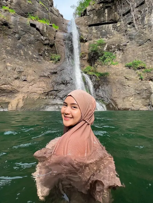 Alam bebas selalu dieksplor oleh Alifhia Fitri termasuk keindahan air terjun. Pesona senyum manis Fhia saat berenang di air terjun ini sukses bikin banyak orang terpesona. Tidak heran meski berenang di air terjun, kecantikan Alifhia Fitri tetap terlihat dan berhasil curi perhatian. (Liputan6.com/IG/@alifhiafitri)