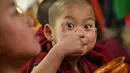 Biksu muda Buddha meminum teh paginya di dalam biara utama Tawang di kota Tawang di negara bagian Arunachal Pradesh, India timur laut pada 5 April 2023. (AFP/Arun Sankar)