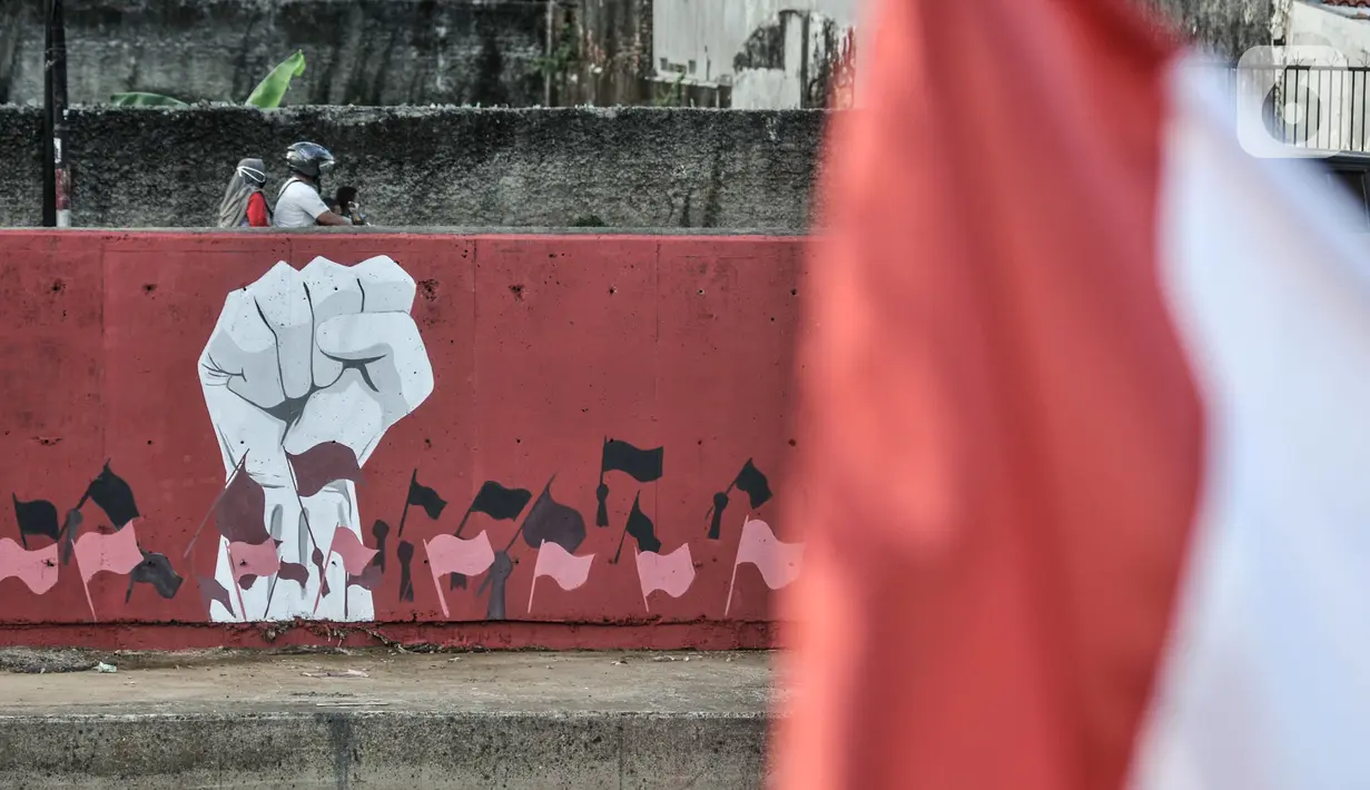 Mural bertema HUT ke-75 RI menghiasi jalan di Kampung Melayu, Jakarta, Minggu (16/8/2020). Jelang HUT ke-75 RI, mural bernuansa Merah Putih banyak menghiasi jalanan Ibu Kota guna memberi semangat nasionalisme kepada warga di tengah pandemi COVID-19. (merdeka.com/Iqbal S.Nugroho)