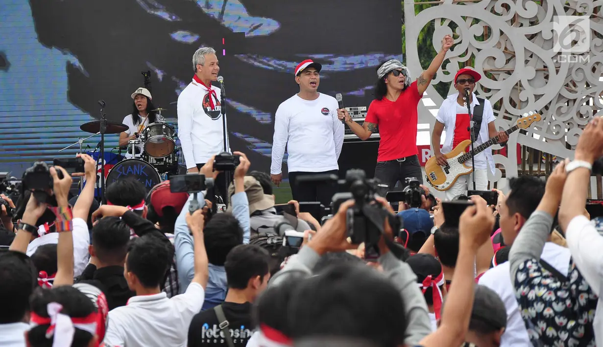 Grup band musik Slank duet dengan Gubernur Jawa Tengah, Ganjar Pranowo saat memeriahkan Apel Kebangsaan 'Kita Merah Putih' di lapangan Pancasila Simpang Lima Semarang, Minggu (17/3). (Liputan6.com/Gholib)