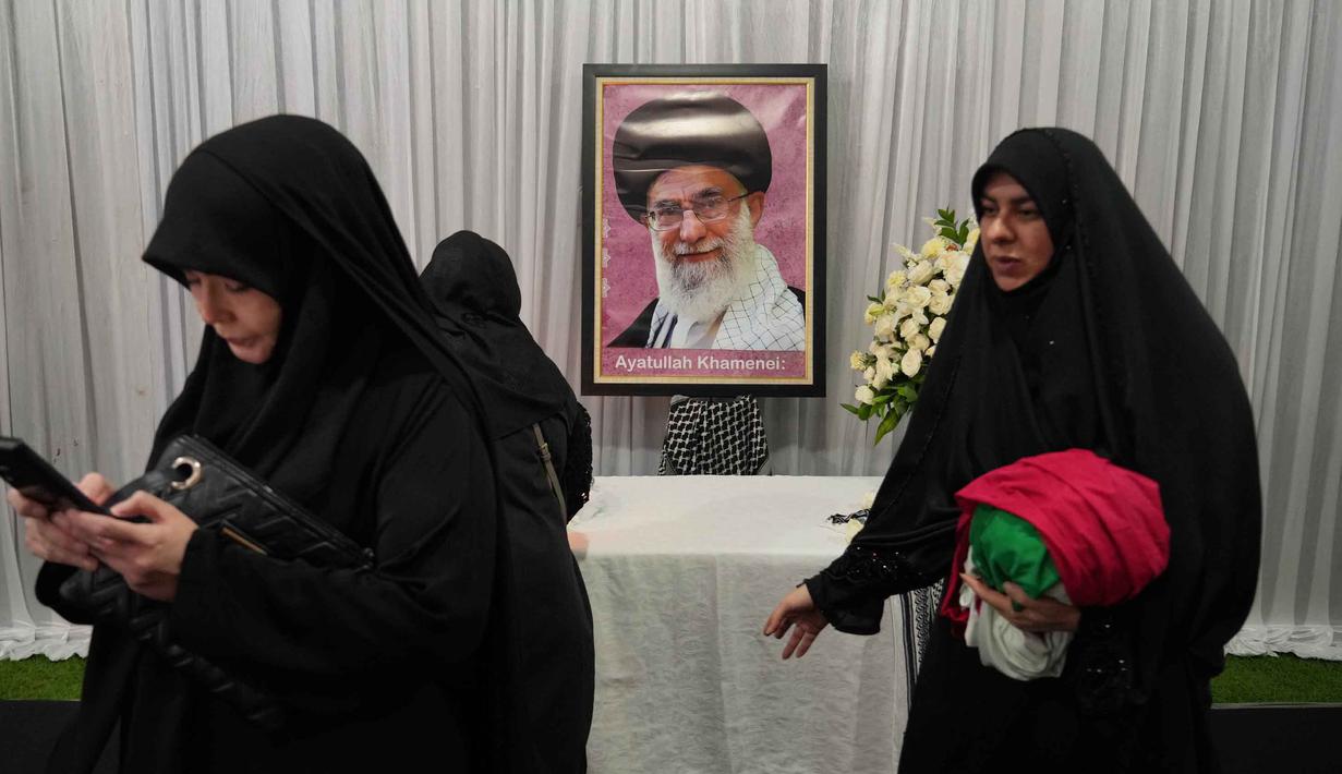 Televisi Pemerintah Iran mengonfirmasi bahwa Pemimpin Tertinggi Iran Ali Khamenei gugur dalam serangan itu. Tampak dalam foto, para wanita berjalan melewati potret mendiang Pemimpin Tertinggi Iran Ayatollah Ali Khamenei di kediaman duta besar Iran untuk Indonesia, Jakarta, Kamis 5 Maret 2026. (AP Photo/Tatan Syuflana)