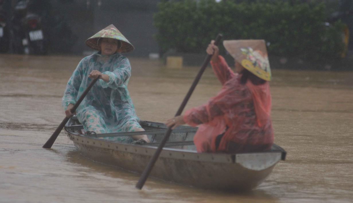 Orang-orang mendayung perahu di jalanan yang terendam banjir di Hue, Vietnam, Selasa, 28 Oktober 2025. Ini menjadi tertinggi setelah sebelumnya, pada tahun 1999, curah hujan di Hue tercatat sebesar 990 milimeter. (Van Dung/VNA via AP)