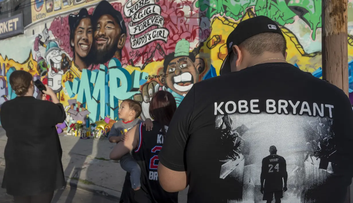 Orang-orang berkumpul di depan mural karya Muck Rock dan Mr79lts bergambar Kobe Bryant dan putrinya, Gianna Bryant di Los Angeles, Senin (27/1/2020). Pemain basket legendaris NBA Kobe Bryant bersama putrinya, Gianna tewas dalam kecelakaan helikopter pada Senin (27/1). (DAVID MCNEW/GETTY IMAGES/AFP)