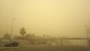 Kendaraan melaju di jalan di ibu kota Irak, saat debu tebal akibat badai pasir menyelimuti kota itu, pada Senin (23/5/2022). Irak menutup bandara dan gedung-gedung publik saat badai pasir -- yang kesembilan sejak pertengahan April -- melanda negara itu, kata pihak berwenang. (Sabah ARAR / AFP)