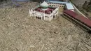 Pemandangan udara menunjukkan sisa-sisa pepohonan yang tumbang di pesantren dan masjid Darul Mukhlisin setelah banjir bandang di Aceh Tamiang, pada Rabu 10 Desember 2025. Banjir bandang dan tanah longsor yang menerjang Aceh, Sumatera Utara, dan Sumatera Barat yang terjadi beberapa pekan lalu mengakibatkan kerusakan parah pada sejumlah wilayah. (Aditya Aji/AFP)
