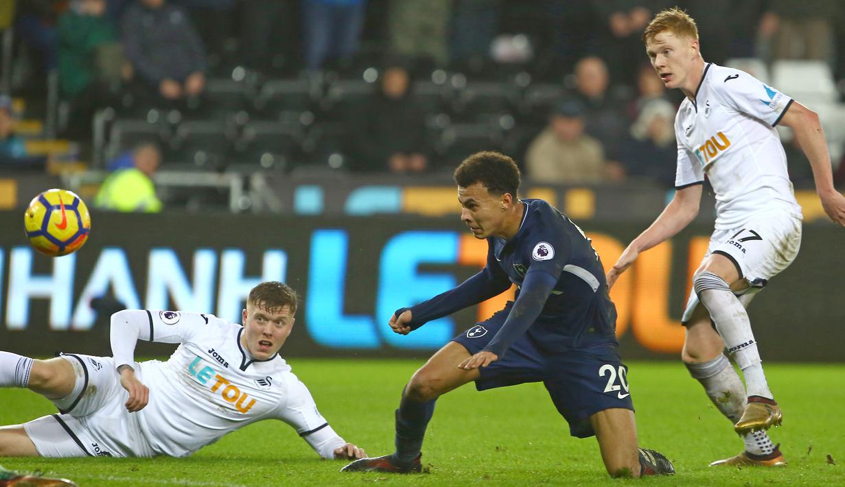 Pemain Tottenham, Dele Alli (tengah) berebut bola dengan para pemain Swansea City pada lanjutan Premier League di The Liberty Stadium, Swansea, (2/1/2018). Tottenham menang 2-0. (AFP/Geoff Caddick)