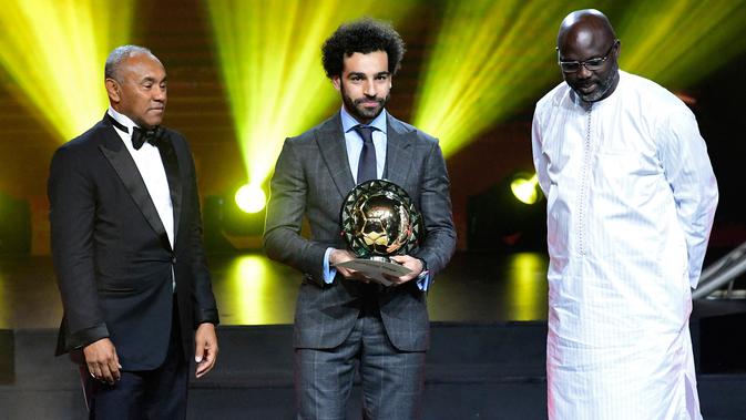 Winger Liverpool, Mohamed Salah berpose setelah menerima penghargaan Pemain Terbaik Afrika 2018 dalam malam penghargaan di Dakar, Senegal, Selasa (8/1). Pemain asal Mesir tersebut menang untuk kedua kalinya secara beruntun. (SEYLLOU/AFP)