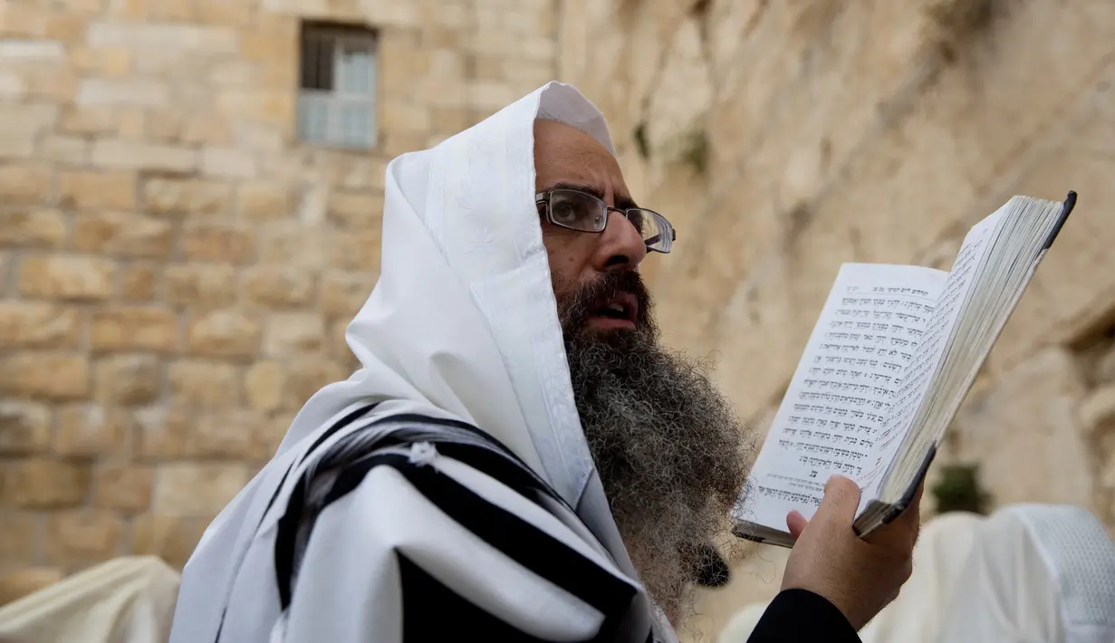 Seorang pria dari Kohanim atau kasta imam Yahudi berdoa menjelang Paskah di depan Tembok Barat, Yerusalem (13/4). Kohanim diyakini keturunan imam yang melayani Tuhan di kuil Yahudi sebelum dihancurkan. (AP Photo / Ariel Schalit) 