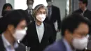 Menteri Luar Negeri Korea Selatan Kang Kyung-wha (tengah) mengenakan masker tiba untuk menghadiri konferensi untuk diplomat asing tentang situasi wabah virus corona di Korea, di kementerian luar negeri di Seoul, Jumat (6/3/2020). (Jung Yeon-je/Pool Photo via AP)