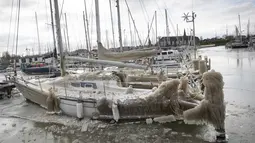 Es terbentuk di atas kapal di marina Monnickendam, Belanda, Selasa (9/2/2021).  Dengan perkiraan suhu beku selama lebih dari seminggu, demam es melanda seluruh Belanda dan menciptakan tantangan bagi pihak berwenang untuk mencoba menegakkan aturan social distancing. (AP Photo/Peter Dejong)