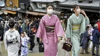 Pengunjung berjalan di sepanjang tujuan wisata di Kyoto, Jepang barat, Senin (13/3/2023). Taman hiburan di Jepang seperti Tokyo Disneyland, Kereta Api Jepang dan operator bioskop Toho termasuk di antara perusahaan besar yang mengizinkan pelanggan untuk tidak menggunakan masker mulai Senin. (Kyodo News via AP)