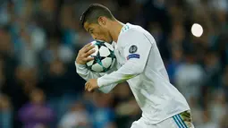 Pemain Real Madrid, Cristiano Ronaldo mencium bola setelah mencetak gol lewat penalti pada laga lanjutan babak penyisihan Grup H Liga Champions di Santiago Bernabeu, Selasa (17/10). Madrid ditahan imbang tamunya Tottenham Hotspur 1-1.  (AP/Francisco Seco)
