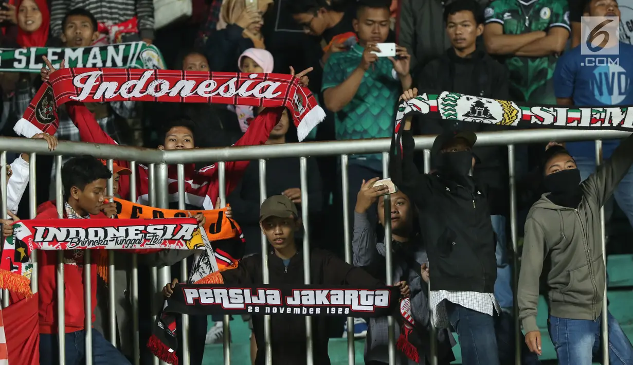 Suporter tim Elang Jawa membentangkan syal saat menyaksikan laga uji coba Timnas Indonesia u-19 melawan PSS Sleman di Stadion Maguwohardjo, Sleman, Sabtu (12/8). Laga ini persiapan Timnas sebelum Piala AFF U-18, Myanmar. (Liputan6.com/Helmi Fithriansyah)