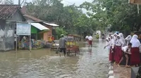 Para siswa yang bersekolah di kawasan bencana ada yang girang dengan kehadiran banjir berulang di Cilacap itu. (Liputan6.com/Muhamad Ridlo)