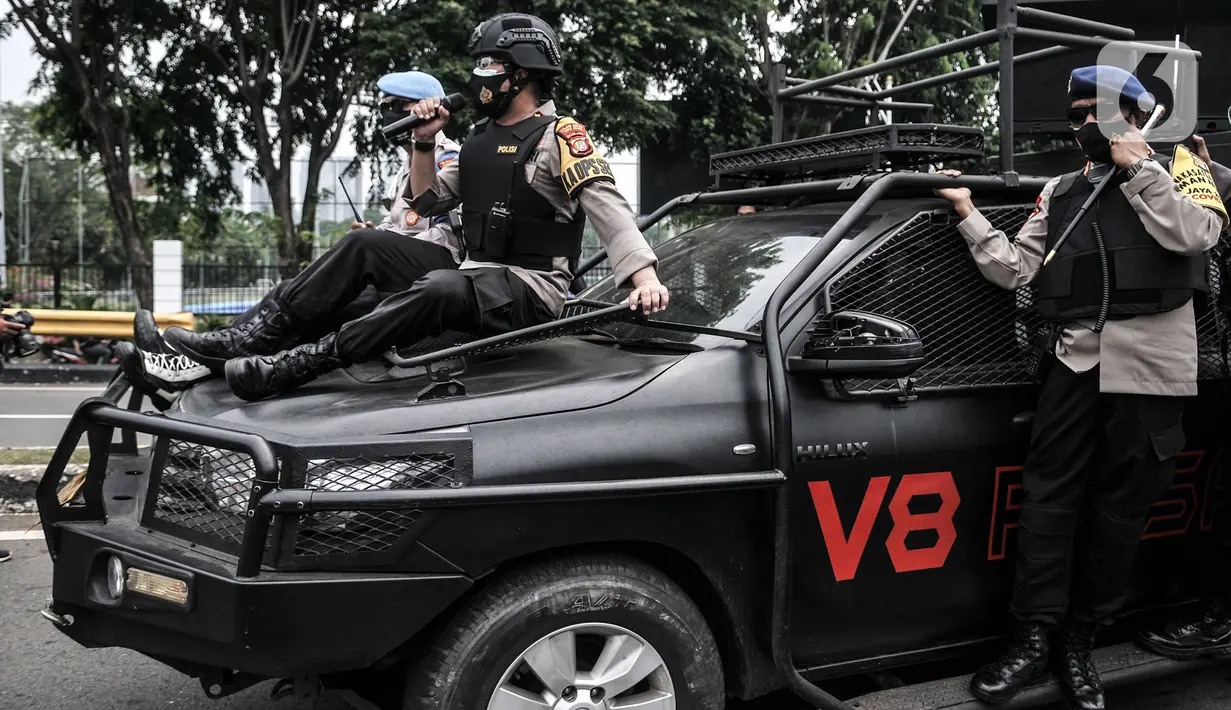 Aparat kepolisian menggunakan toa saat mengusir massa buruh yang akan berunjuk rasa di sekitar Gedung DPR RI, Jakarta, Kamis (8/10/2020). Polri mengerahkan 2.500 personel BKO Brimob Nusantara untuk mengamankan unjuk rasa UU Cipta Kerja di Gedung DPR dan sekitarnya. (merdeka.com/Iqbal S. Nugroho)