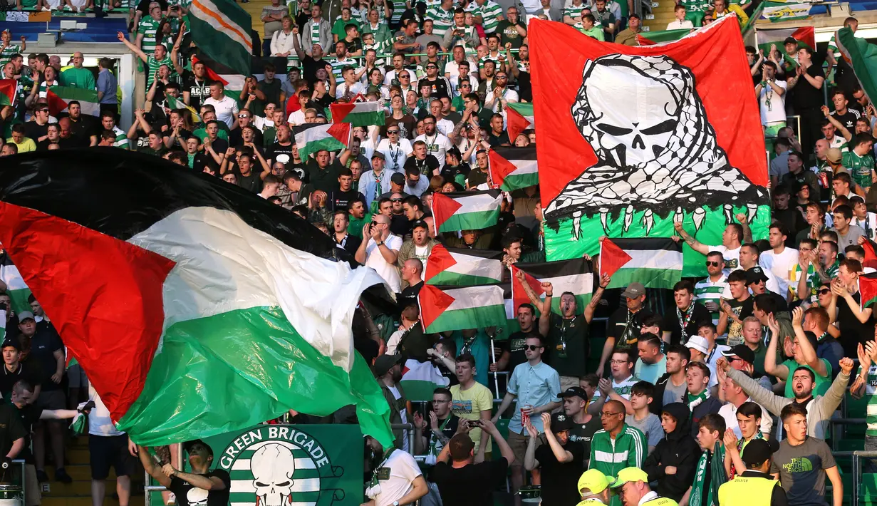 Para suporter Celtic mengibarkan bendera Palestina saat melawan Hapoel Beer Sheva asal Israel di pertandingan babak kualifikasi play off Liga Champions di Celtic park, (19/8).  Celtic menang atas Hapoel dengan skor 5-2. (REUTERS/Russell Cheyne)