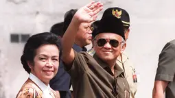 Presiden BJ Habibie didampingi istrinya Ainun Habibie melambaikan tangan kepada wartawan saat tiba di pusat perbelanjaan yang hancur akibat gelombang kekerasan di Chinatown, Jakarta, 26 Mei 1998. Habibie meninggal pada usia 83 tahun akibat gagal jantung dan menua. (AFP Photo/Kemal Jufri)