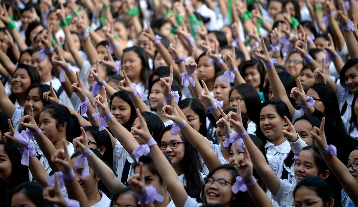 Siswa St. Scholastica College mengacungkan jari telunjuk "nomor satu" saat menari massal dalam aksi One Billion Rising di Filipina, Senin (15/2). Gerakan ini bentuk kampanye untuk menghentikan kekerasan terhadap perempuan. (AFP PHOTO/Noel CELIS)