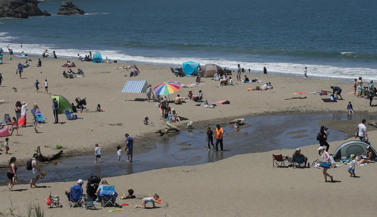 Orang-orang mengunjungi Pantai Baker selama masa pandemi covid-19 di San Francisco pada Minggu (24/5/2020). Warga Amerika Serikat mengabaikan pedoman jarak sosial dan memilih berjemur di pantai ketika angka kematian akibat virus corona di negara itu mendekati 100.000 orang. (AP/Jeff Chiu)