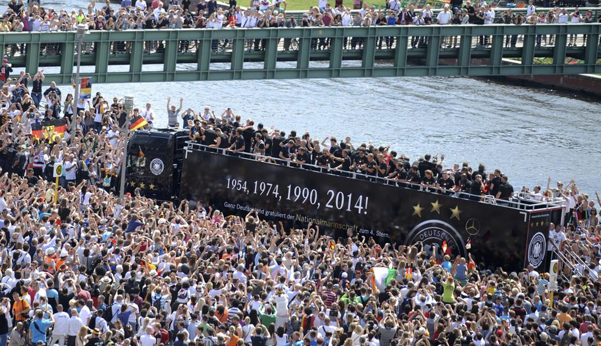 Kerumunan suporter Timnas Jerman memenuhi tepi sungai Spree di pusat kota Berlin, (15/7/2014), untuk menyaksikan parade kemenangan Der Panzer di Piala Dunia 2014. (REUTERS/Steffi Loos)