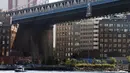 Sebuah kapal melintas di bawah banner bergambar Presiden Rusia Vladimir Putin yang tergantung di Jembatan Manhattan, New York, Kamis (6/10). Terdapat tulisan ‘PEACEMAKER’ (pendamai) yang dicetak tebal pada banner tersebut. (REUTERS/Brendan McDermid)