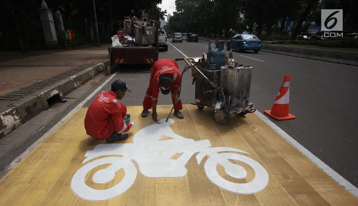 Pekerja mengecat rambu jalur kuning khusus sepeda motor di Jalan Medan Merdeka, Jakarta, Selasa (16/1). Untuk membuat kawasan tersebut tetap tertib, Dishub DKI membuatkan jalur khusus sepeda motor di sepanjang jalan tersebut. (Liputan6.com/Arya Manggala)