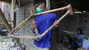 Pekerja tengah mengangkat sepeda dari bahan baku bambu di Akademi Bambu Nusantara (ABN) di BSD, Tangerang Selatan, Selasa (06/9). Sepeda tersebut di jual kisaran Rp2,5 Juta hingga Rp25 juta tergantung jenis tingkat kesulitan.  (Liputan6.com/Angga Yuniar)