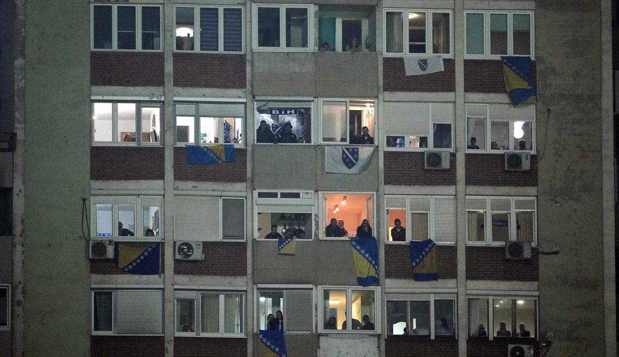 Bertanding di Stadion Bilino Polje, Zenica, Selasa 31 Maret 2026 waktu setempat atau Rabu 1 April 2026 dini hari WIB, Bosnia dan Herzegovina menang lewat adu penalti 4-1. Tampak dalam foto, suporter Timnas Bosnia dan Herzegovina menyaksikan pertandingan final play-off kualifikasi Piala Dunia 2026 zona Eropa melawan Italia dari sebuah gedung apartemen tepat di luar stadion, Zenica, Bosnia, Selasa, 31 Maret 2026. (Fabio Ferrari/LaPresse via AP)