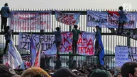 Mahasiswa memasang spanduk di pagar saat berunjuk rasa di depan Gedung DPR/MPR, Jakarta, Senin (23/9/2019). Dalam aksinya mereka menolak pengesahan RUU KUHP dan revisi UU KPK. (Liputan6.com/JohanTallo)