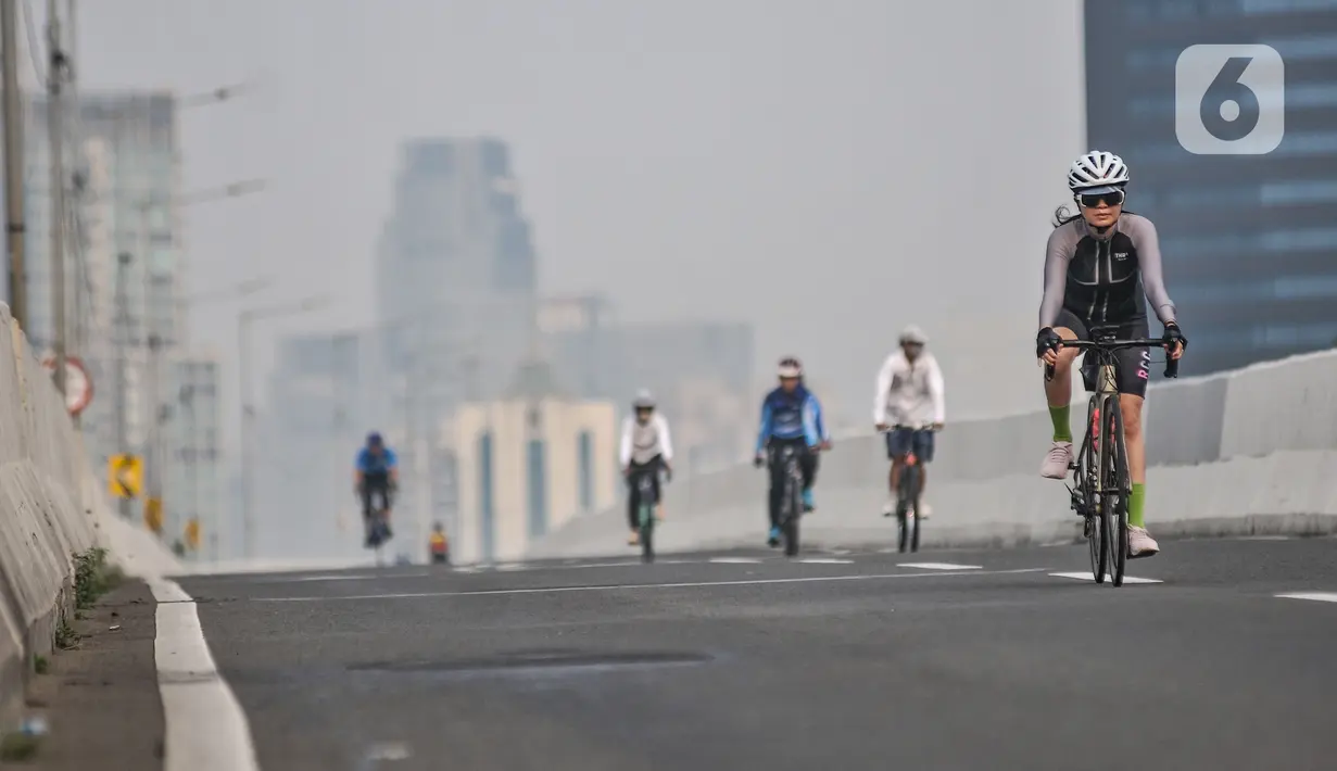 Pesepeda melintasi Jalan Layang Non Tol (JLNT) Kampung Melayu-Tanah Abang saat uji coba jalur sepeda balap atau Road Bike, Jakarta, Minggu (23/5/2021). Tidak hanya pesepeda balap, pengguna sepeda jenis lain pun turut meramaikan uji coba ini. (merdeka.com/Iqbal S Nugroho)