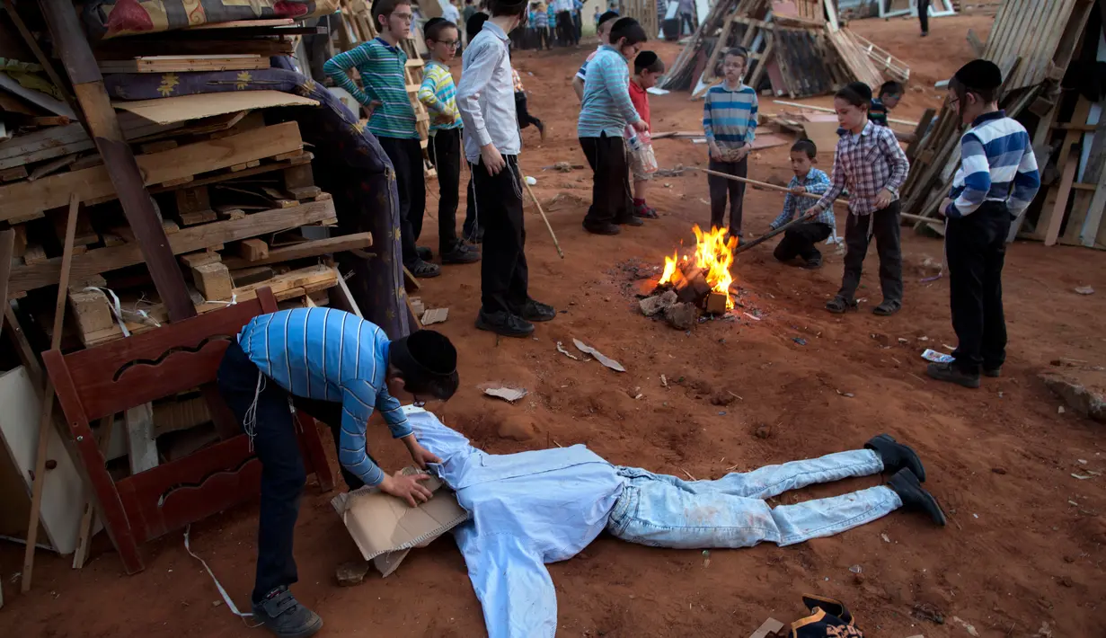 Anak-anak Yahudi Ultra Ortodoks menyusun kayu dan boneka "evil man" untuk dibakar saat perayaan hari Lag Ba'Omer di Bnei Brak, Israel (2/5). (AP Photo / Oded Balilty)