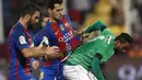 Pemain Barcelona, Arda Turan dan Sergio Busquets, berebut bola dengan pemain Al Ahli, Ali al-Zubaidi, pada laga persahabatan di Stadion Thani bin Jassim, Doha, Selasa (13/12/2016) waktu setempat. (AFP/Karim Jaafar)