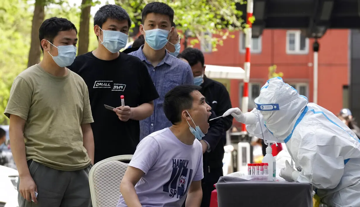 <p>Warga mengantre untuk tes COVID-19 di luar sebuah hotel di Distrik Haidian, Beijing, China, Selasa (26/4/2022). Beijing memberlakukan pengujian massal dan menutup akses ke lingkungan karena berupaya menahan wabah COVID-19 baru. (AP Photo/Ng Han Guan)</p>