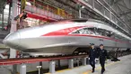 Dua mekanik berjalan melewati sebuah kereta peluru Fuxing CR400AF di stasiun pemeliharaan depo gerbong kereta di Kota Chongqing, China barat (23/12/2020). Kereta yang dioperasikan di Chongqing Railway untuk pertama kalinya, melakukan debut di Chongqing pada Rabu (23/12). (Xinhua/Tang Yi)