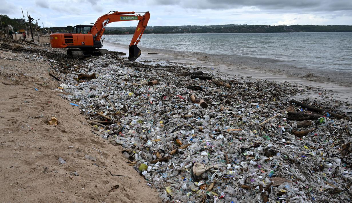 Dinas Lingkungan Hidup dan Kebersihan (DLHK) Kabupaten Badung, Bali menerjunkan sejumlah personel dan alat berat untuk membersihkan dan mengangkut sampah dari pantai Kedonganan. (SONNY TUMBELAKA/AFP)