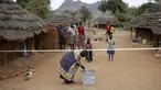 Warga suku Karamojong memasukkan kertas suara kedalam kotak di TPS desa dekat kota Kaabong, Uganda, (18/2). Uganda memiliki berbagai macam suku yang warganya masih tertinggal dengan kota - kota besar. (REUTERS / Goran Tomasevic)