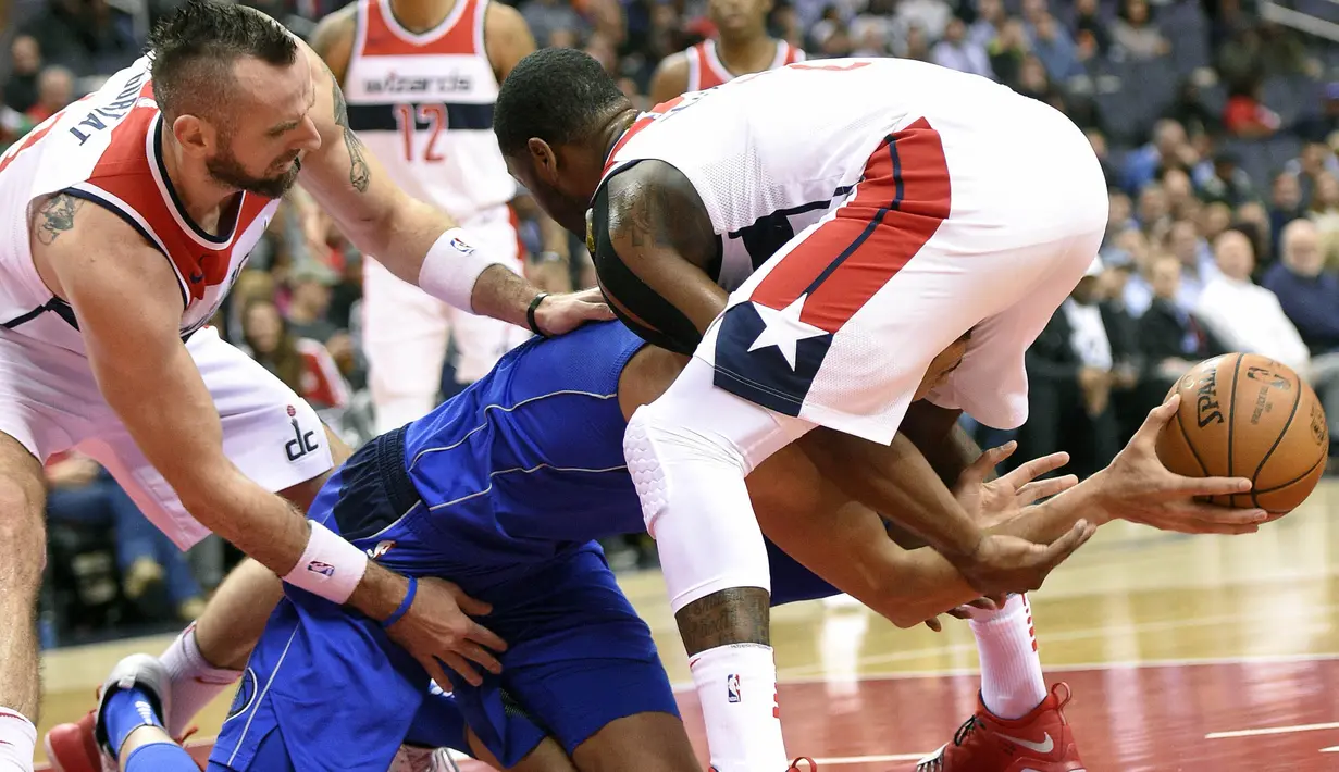 Pebasket Dallas Mavericks, Salah Mejri, berebut bola dengan pebasket Washington Wizards, Marcin Gortat, dan John Wall, pada laga NBA di Capital One Arena, Selasa (7/11/2017). Mavericks menang 113-99 atas Wizards. (AP/Nick Wass)