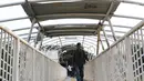 Pejalan kaki melintasi jembatan penyeberangan orang (JPO) Jayakarta yang atapnya rusak dan hilang di Menteng, Jakarta, Jumat (11/1). Kondisi JPO yang rusak mengganggu kenyamanan pejalan kaki. (Liputan6.com/Immanuel Antonius)