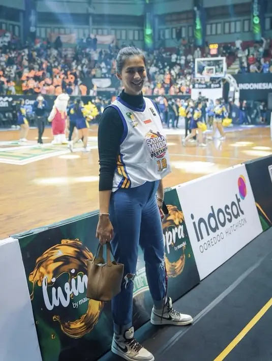 Tak hanya olahraga, ia juga gemar menonton pertandingan olahraga seperti basket. Ia tampil dengan jersey basket di atas long sleeve hitam halterneck, dipadukan celana denim dan sepatu Nike. (@paula_verhoeven)