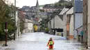 Seorang petugas pemadam kebakaran Prancis berjalan di jalanan yang tergenang banjir di Isques, Prancis Utara pada tanggal 7 November 2023. (DENIS CHARLET/AFP)