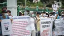 Sejumlah pengungsi Afghanistan membawa spanduk saat berunjuk rasa di kawasan Monas, Jakarta, Rabu (19/1/2022). Mereka menuntut kejelasan untuk berangkat ke negara ketiga setelah lama tinggal di pengungsian. (Liputan6.com/Faizal Fanani)