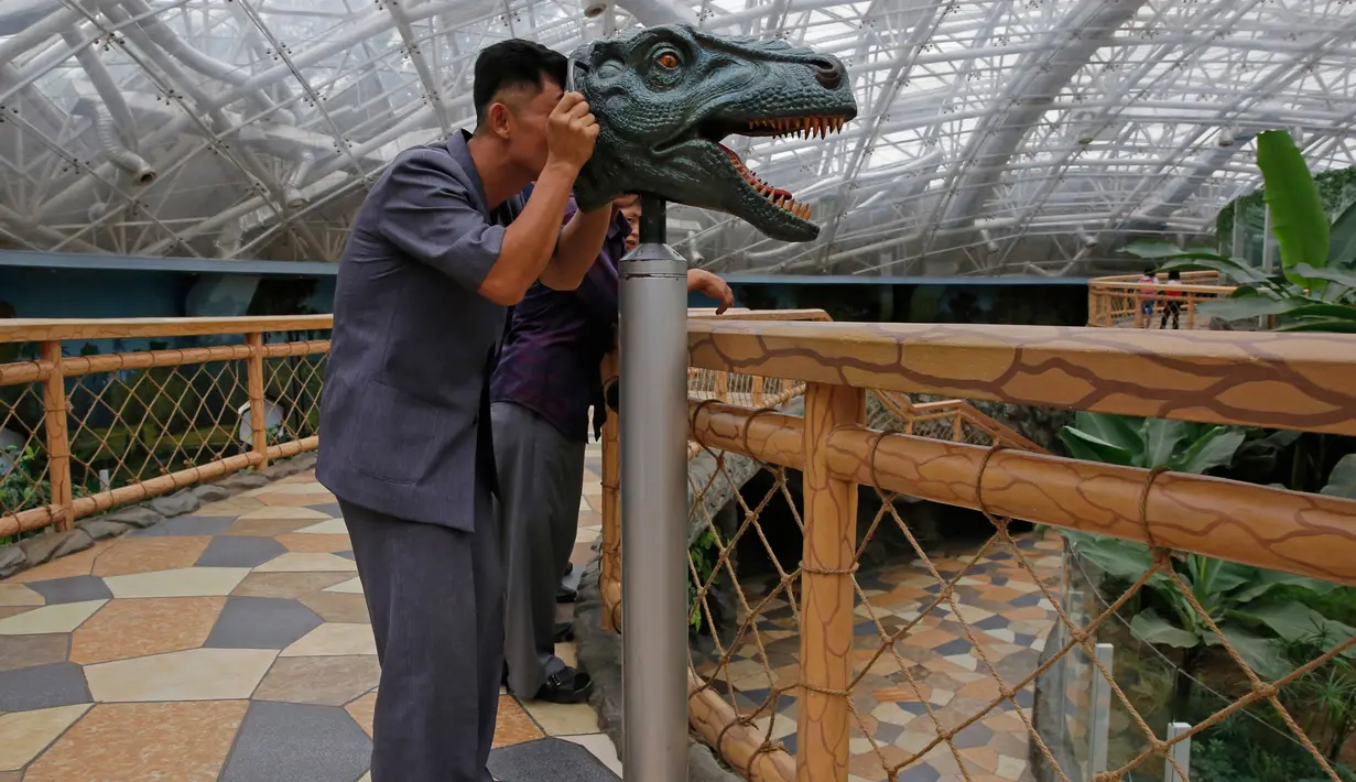 Seorang pria melihat melalui perangkat untuk mempelajari visi dinosaurus di Kebun Binatang di Pyongyang, Korea Utara (15/9). Kebun binatang nasional Korea Utara ini  terletak dekat Mt. Taesong di pusat kota Pyongyang. (AP Photo/Kin Cheung)
