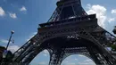 Turis berjalan menjauh dari Menara Eiffel di Paris, Kamis (2/8). Karyawan menara Eiffel mogok memprotes kebijakan baru mengenai akses masuk bagi wisatawan yang memicu antrean menjadi lebih panjang dan lama. (AP Photo/Michel Euler)