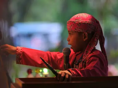 Seorang anak menunjukkan keahliannya menjadi dalang selama festival Dalang Bocah di Kawasan Kota Tua, Jakarta (20/11). Festival kali keenam ini diikut 22 peserta dari kota-kota di sekujur Pulau Jawa, Lampung dan NTB. (Liputan6.com/Gempur M Surya)