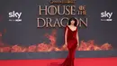 Olivia Cooke berpose di karpet merah saat tiba untuk menghadiri pemutaran perdana serial drama asli HBO "House of the Dragon" di Leicester Square Gardens, di London (15/8/2022). Olivia Cooke juga tampil memesona dengan memakai anting yang berkilau dengan gaun merahnya. (AFP/Hollie Adams)