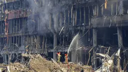Petugas pemadam kebakaran memadamkan api setelah serangan sebuah pusat perbelanjaan di Kiev, Ukraina, Senin (21/3/2022). Delapan orang tewas dalam serangan tersebut. (AP Photo/Efrem Lukatsky)